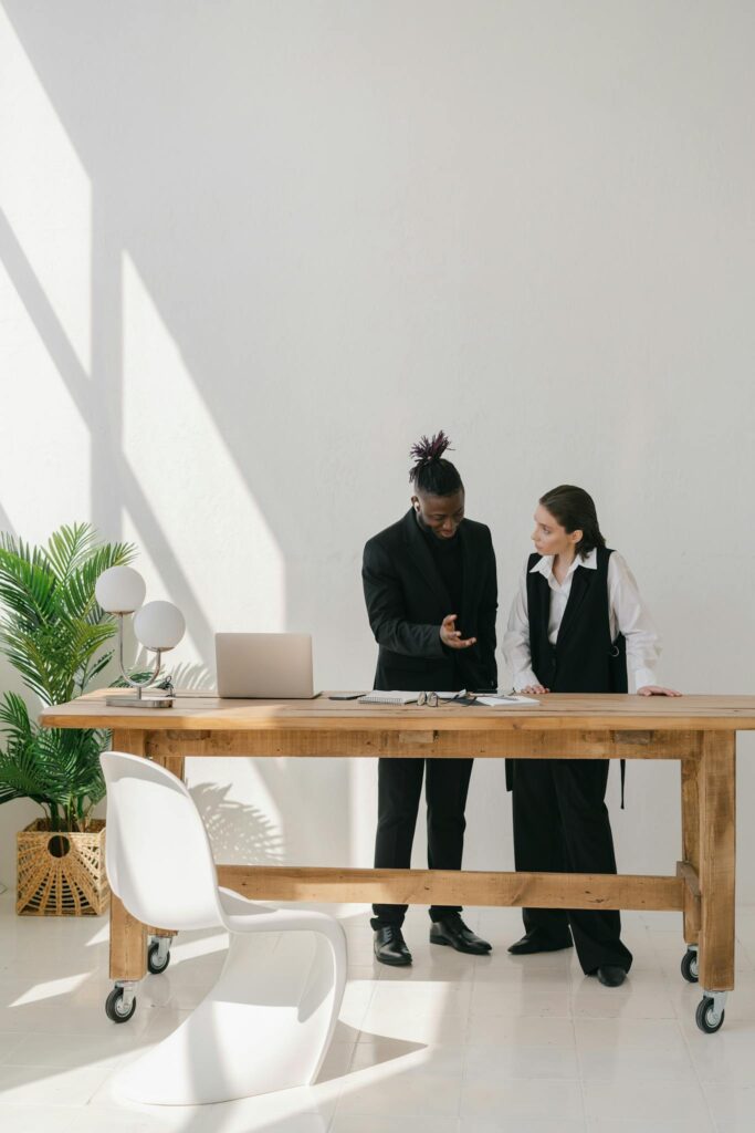 Man and Woman Standing Beside Brown Wooden Table